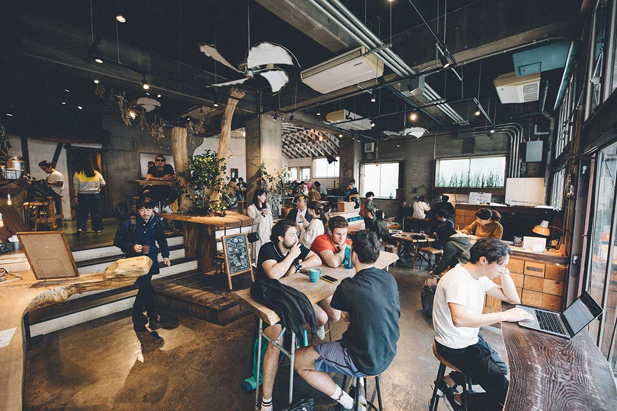 Nui. HOSTEL & BAR LOUNGE — 蔵前 · 旧玩具卸倉庫を翻案した1階ラウンジ、鉄骨現しと大開口