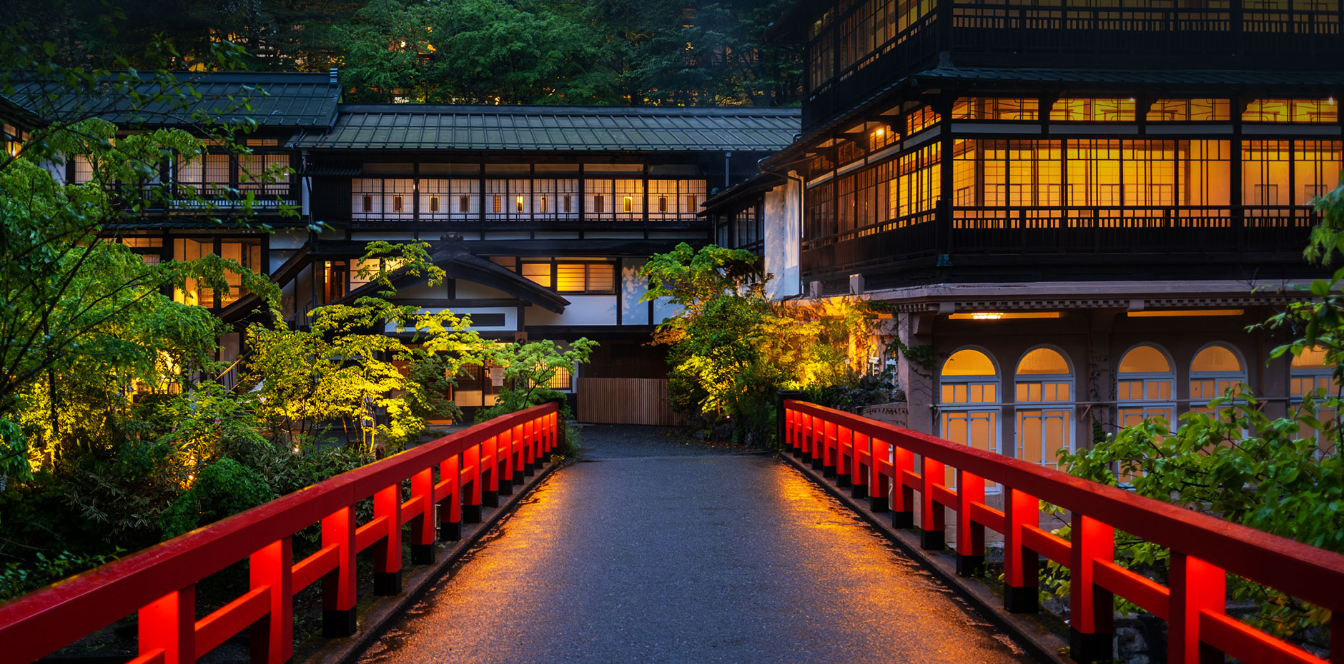 積善館本館 — 四万温泉・新湯地区 · 元禄四年創建の三層木造湯宿、慶雲橋越しの夜景