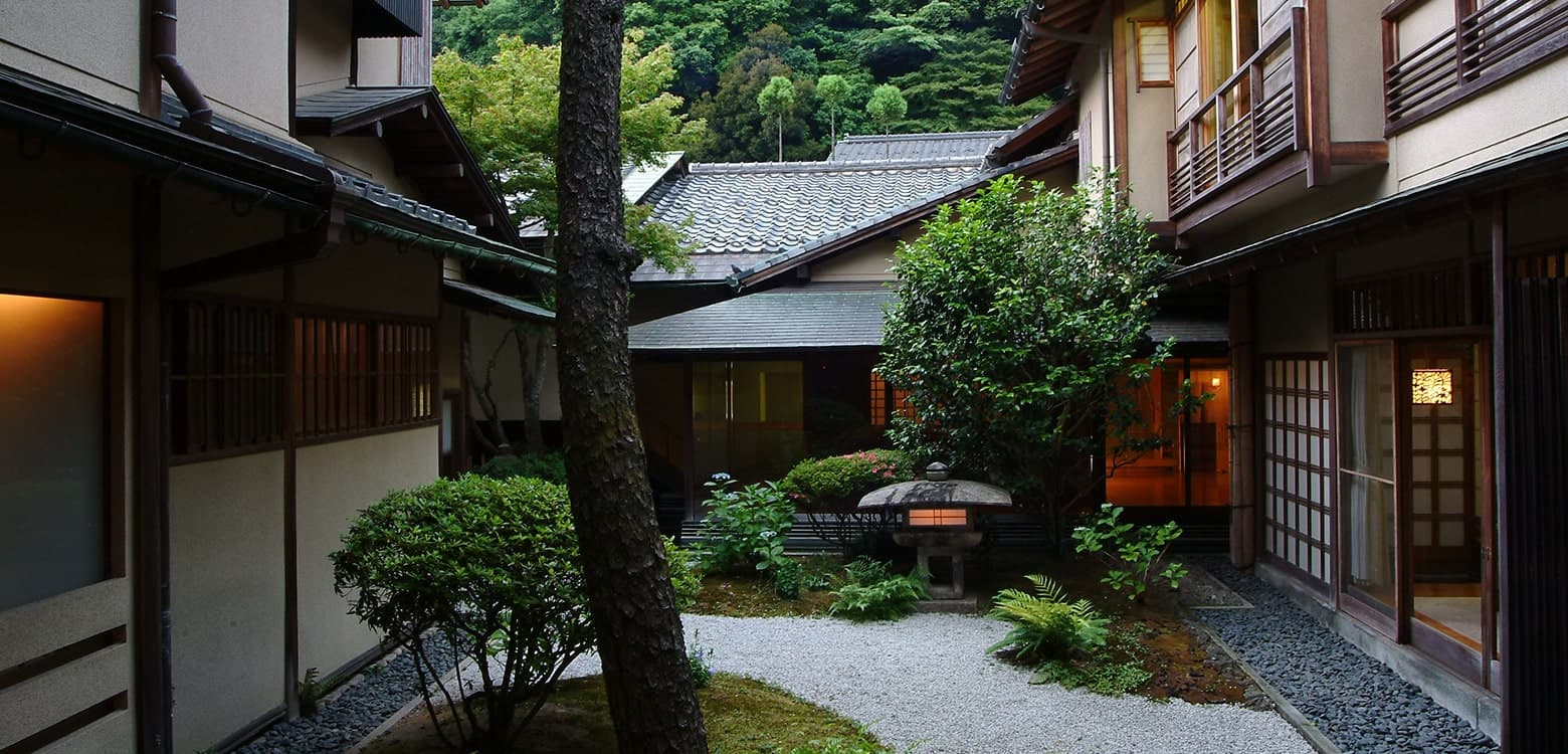 西村屋本館 — 城崎温泉 · 山並みを背景に抱く内庭と数寄屋棟