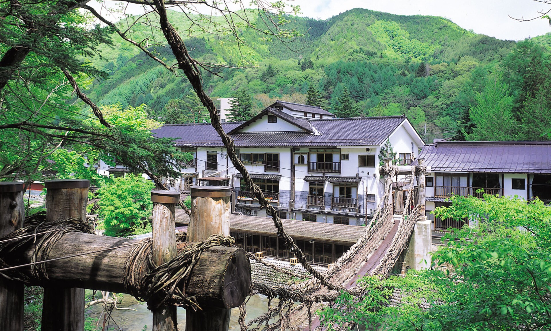 本家伴久 — 栃木・湯西川 · 木造三階建て本館とかずら橋、白壁に越屋根を載せた湯西川温泉発祥の湯宿