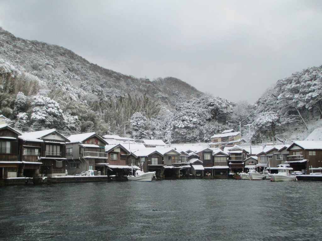 伊根の舟屋群 — 冬の湾、雪を纏う山と海面ぎりぎりの木造軒並み