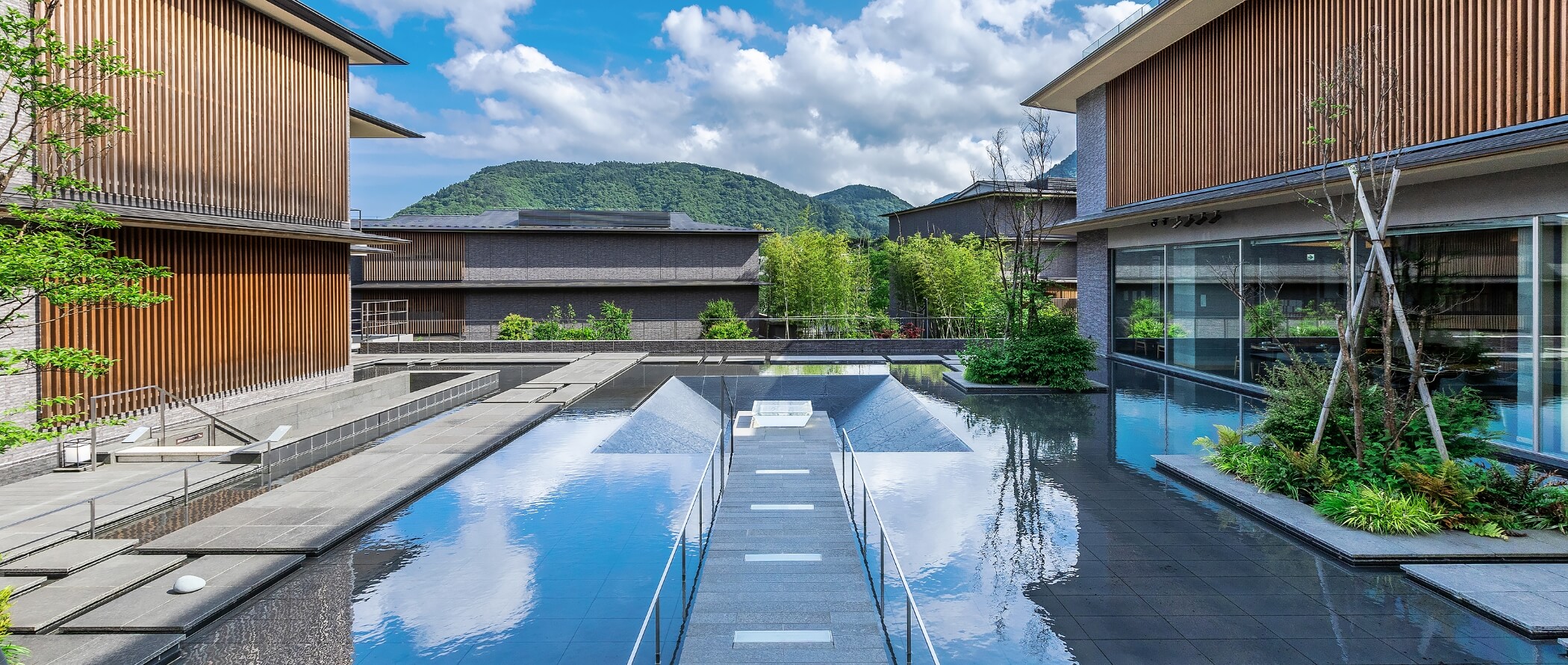 箱根・強羅 佳ら久 — 神奈川・箱根町強羅 · 木格子の客室棟を水盤越しに振り分けた中庭と箱根外輪山