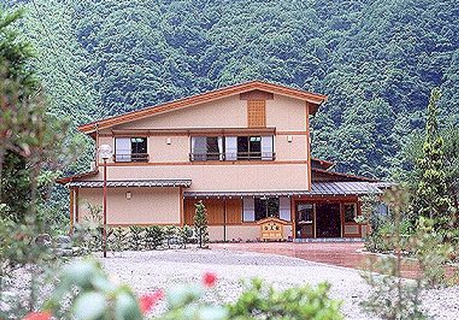 宝美館 — 奥飛騨・新平湯温泉 · 森を背に立つ木造二階建ての小さな宿の外観