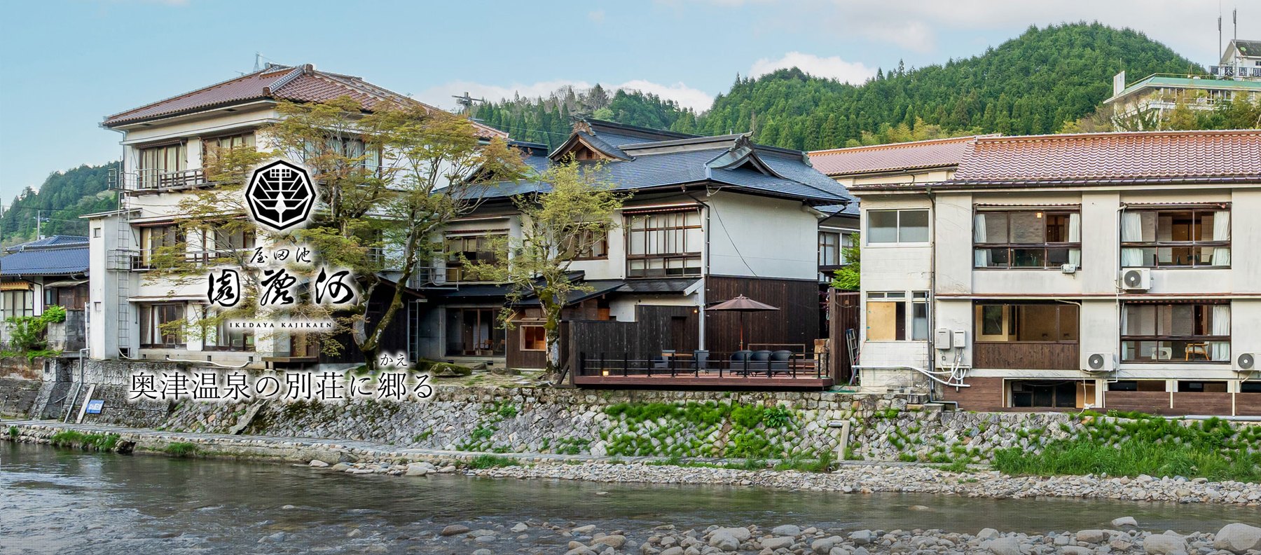 池田屋 河鹿園 — 岡山・奥津温泉 · 吉井川の対岸から見た宿の全景と、川面に張り出した木造の広縁