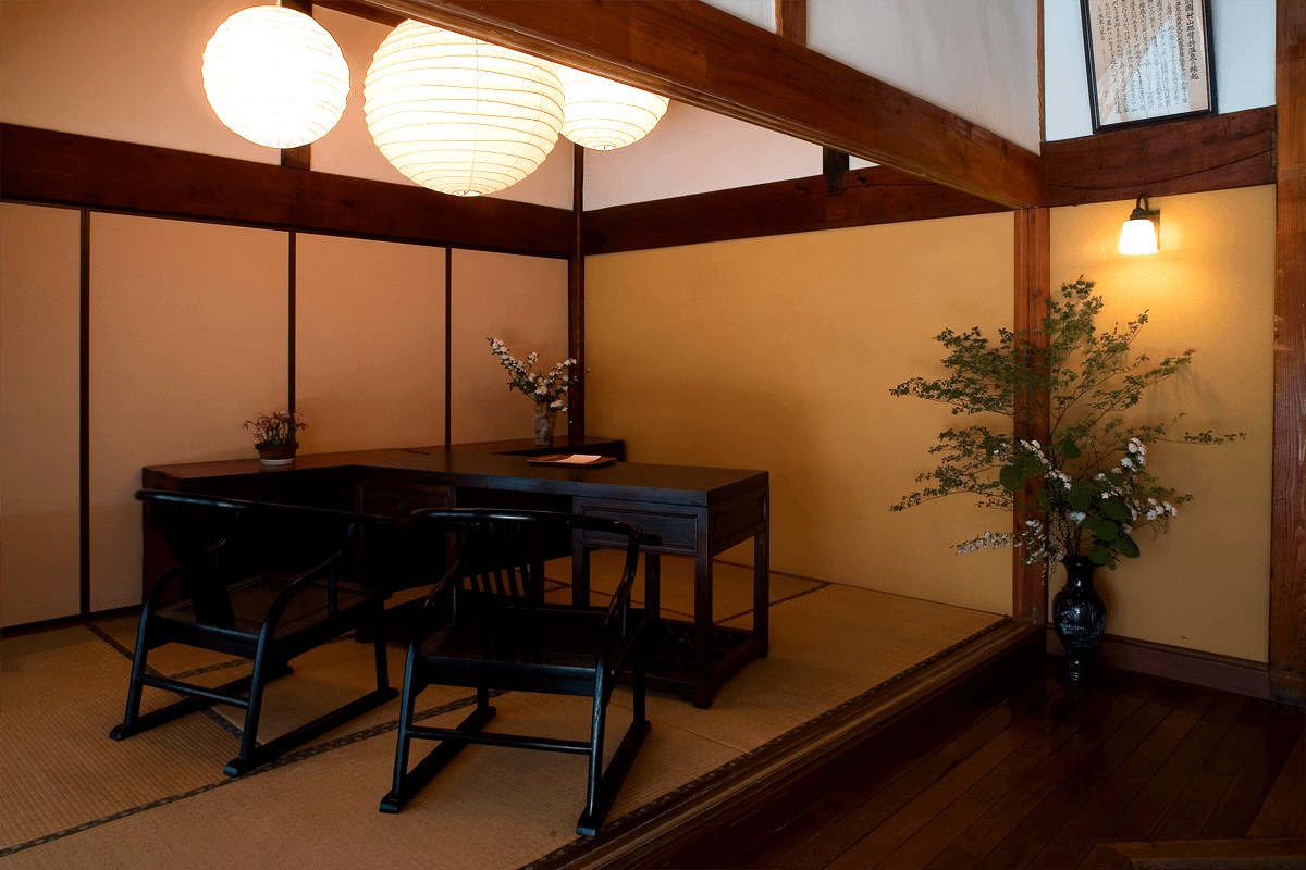肘折温泉 丸屋旅館 — 土壁と差鴨居を残した館内の共用空間 · 全7室のレトロモダンな客室構成