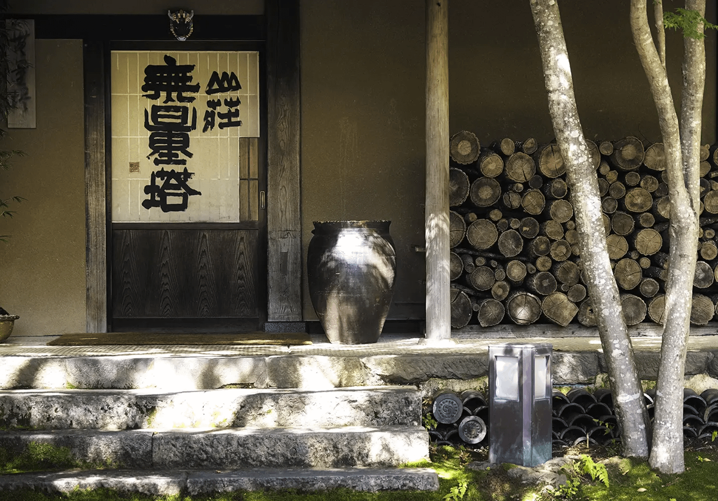 山荘 無量塔 — 由布院・鳥越 · 古民家を移築した全室離れの数寄屋宿、玄関の書と薪積み