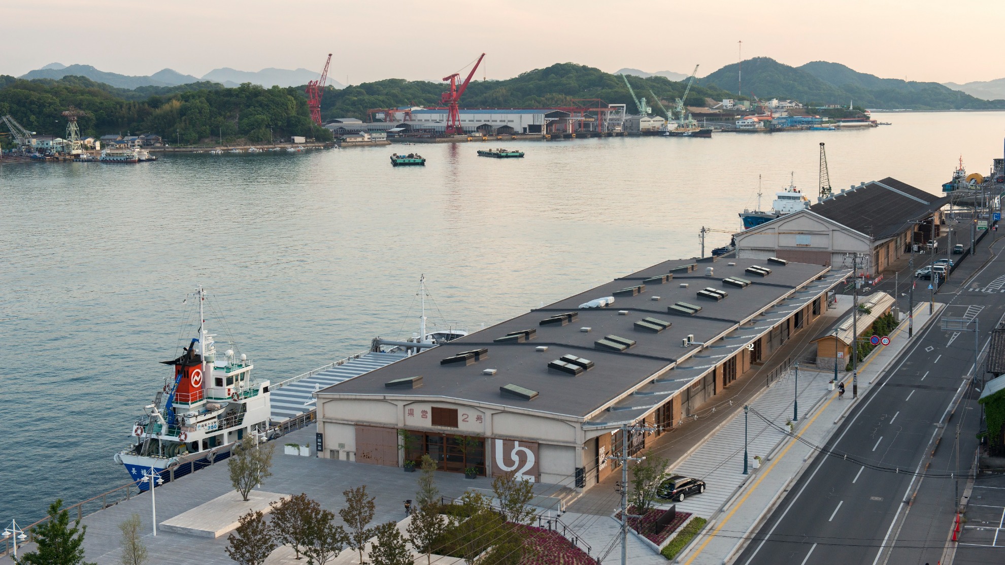HOTEL CYCLE ONOMICHI U2 — 尾道・西御所町 · 1943年築の県営2号上屋を改装した水辺の細長い再生建築と尾道水道