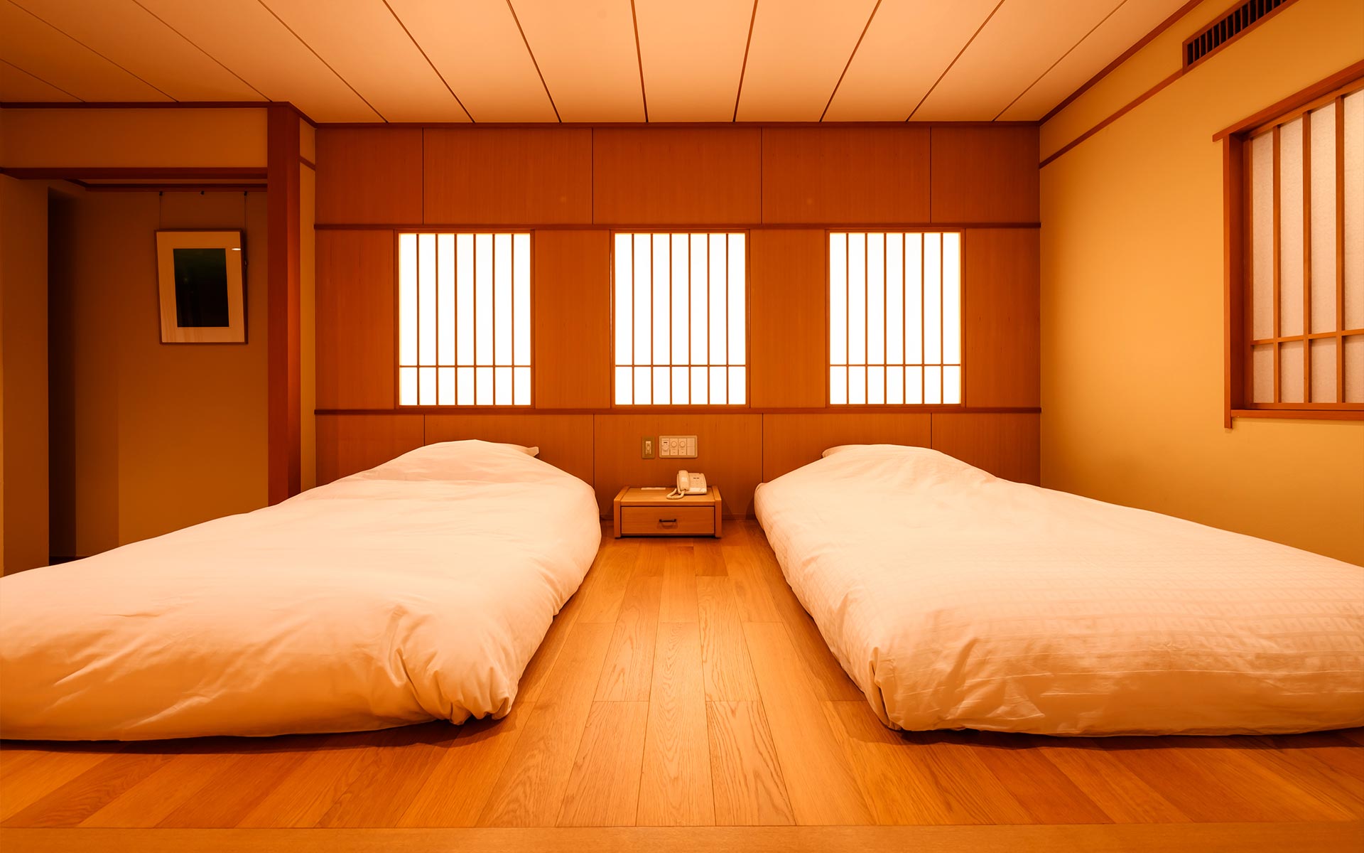 信州別所温泉 玉屋旅館 — 谷筋に沿った木造二層の玄関側外観と、渡り廊下で結ばれる客室棟