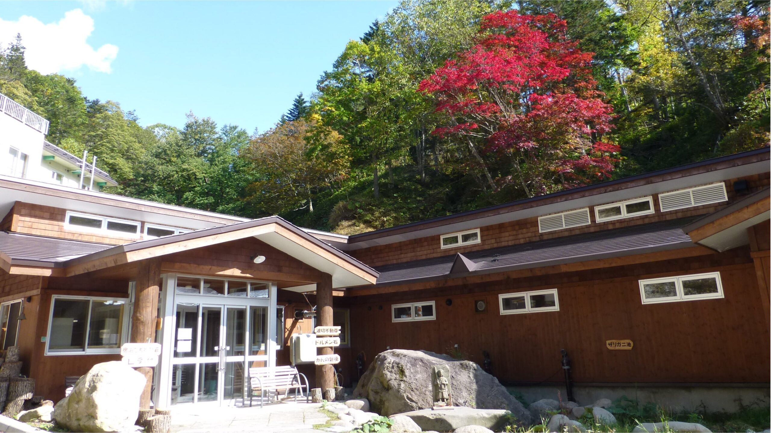 然別峡かんの温泉 — 北海道・鹿追町 · 片流れ屋根の湯処棟と宿泊棟こもれび荘が中庭を挟んで向き合う外観