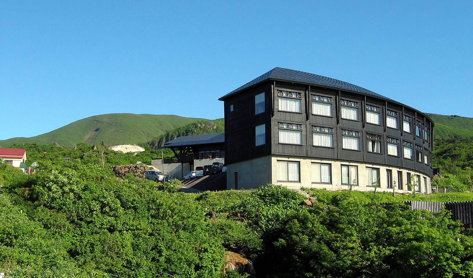 栗駒山荘 — 秋田県東成瀬村・須川高原 · 標高1,100メートル台に建つ全24室の山岳宿、黒い外壁の三層