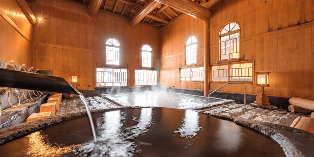 旅館 多郎兵衛 — 秋田県湯沢市・小安峡温泉 · 大浴場「薬師の湯」、樹齢百年の秋田杉の梁と阿蘇の石を敷いた湯船
