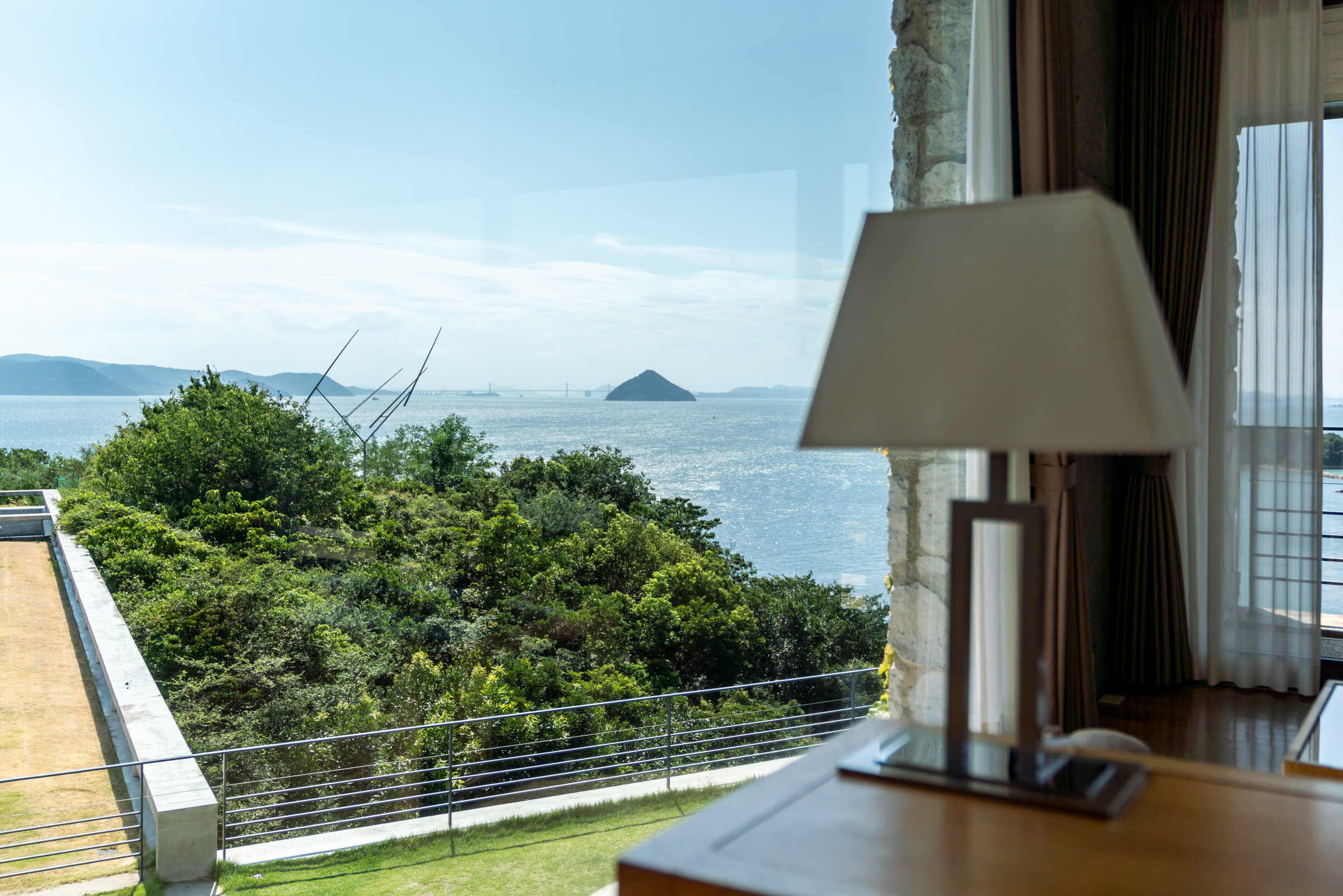 ベネッセハウス 客室からの眺め — 香川県直島町 · 芝生の屋上と屋外彫刻の先に広がる瀬戸内海