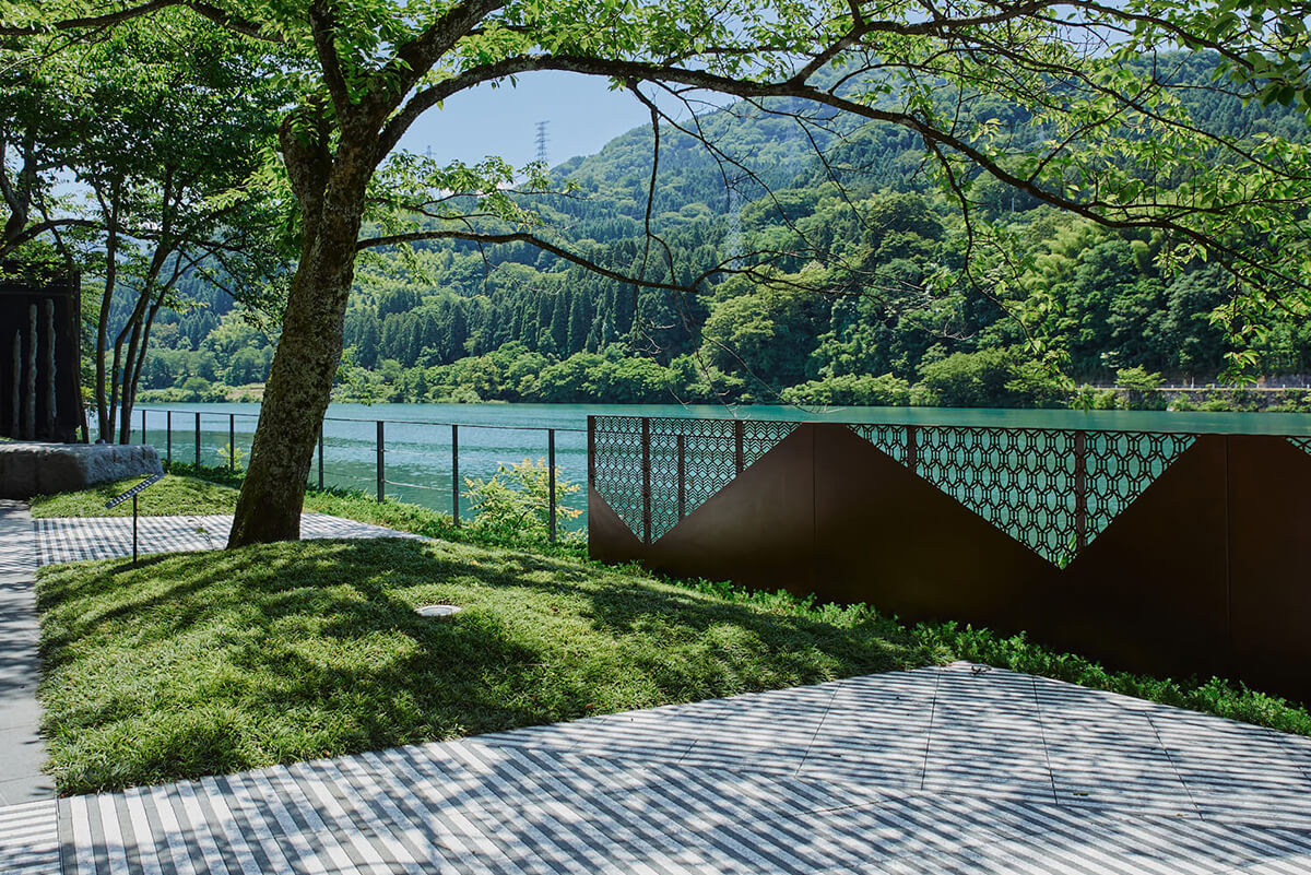 リバーリトリート雅樂倶 アートウォーク — 富山県富山市春日 · 神通峡の水面に沿う石敷きの散策路と金属スクリーン