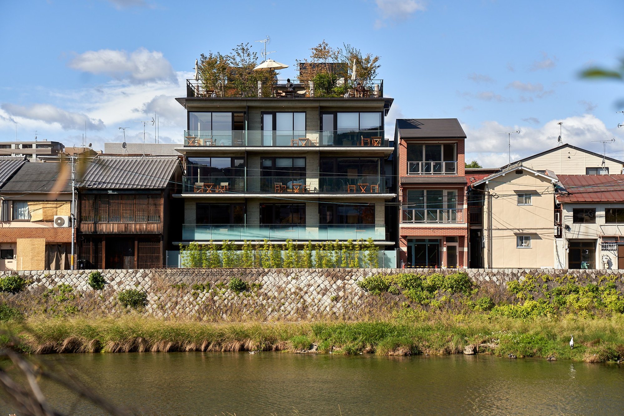 Genji Kyoto — 京都市下京区波止土濃町 · 鴨川西岸に建つ、各階にバルコニーを重ねた外観