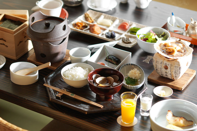 あかん鶴雅別荘 鄙の座 — 料理茶屋「ひな」の和朝食 · 釜で炊いたご飯と小鉢が並ぶ膳
