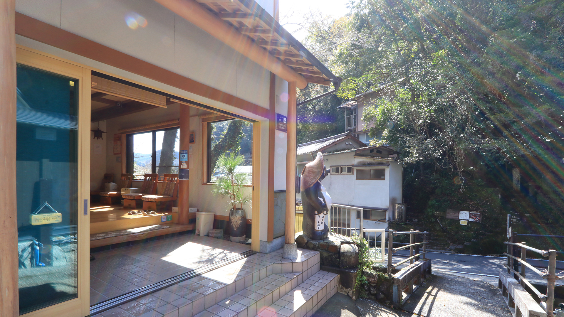 旅館 よしのや — 田辺市本宮町湯の峰 · 湯の谷川沿いの坂に面した、木枠のガラス戸が続く玄関